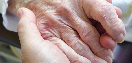 Eine Hand, die die einer alten Person hält. (c) Pixabay.com