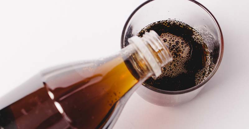 92 Prozent unterschätzen ihren Zuckerkonsum um ein Vielfaches 2 Cola, das von einer Flasche in ein Glas geleert wird. (c) Pixabay.com