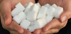 92 Prozent unterschätzen ihren Zuckerkonsum um ein Vielfaches Zwei Hände, in denen Würfelzuckerstücke liegen. (c) Pixabay.com