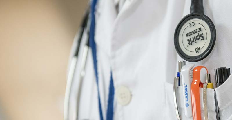 Bildausschnitt: Oberkörper eines Arztes mit einem Stethoskop um den Hals und Stiften im Arztmantel, Stichwort Harnwegsinfekt. (c) Pixabay.com