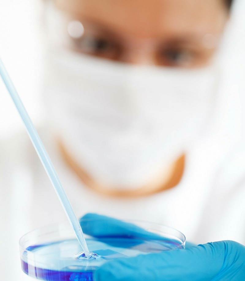 Ein Mikrobiologe, der mit einer Pipette etwas auf ein Glas gibt, Stichwort Krebstherapie. (c) Pixabay.com