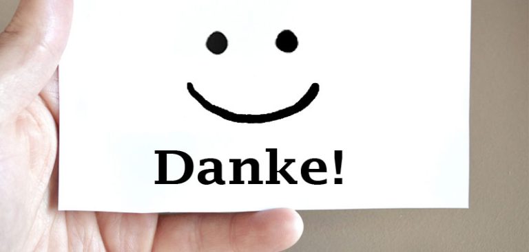 Eine Hand, die einen Zettel mit einem Smiley und Danke! hält. (c) Pixabay.com