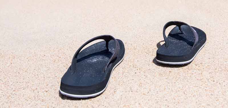 Ein Paar Flip Flops auf einem Sandstrand. (c) Pixabay.com