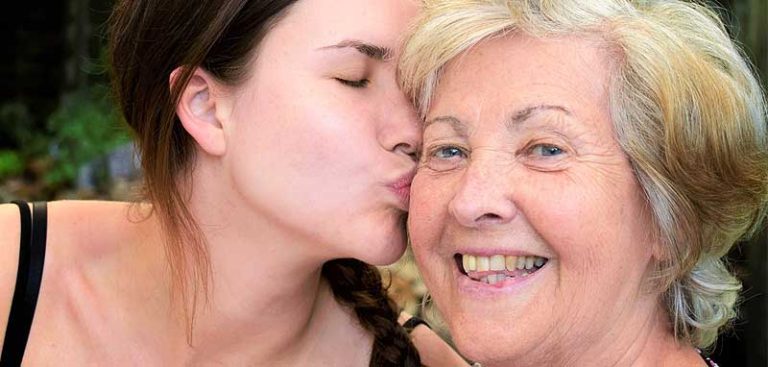 Der Kopf einer älteren Frau, die von einer jüngeren eine Kuss auf die Wange bekommt. (c) Pixabay.com