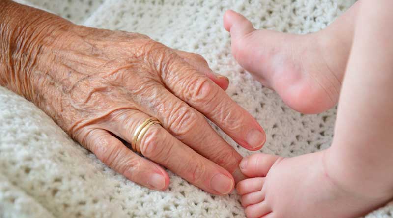 Die Hand einer alten Frau und die Füße eines Babys.
(c) Pixabay.com