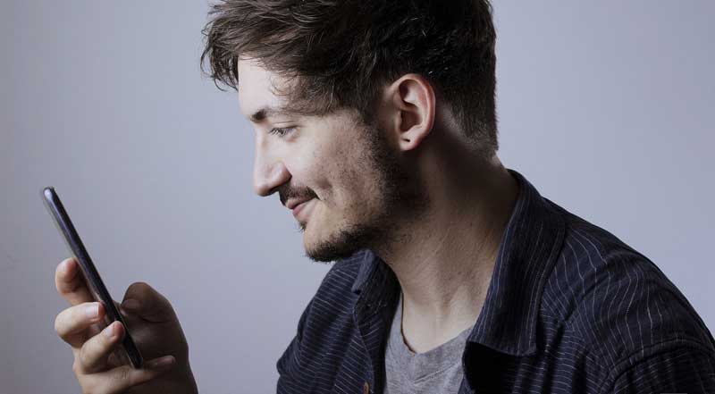 Gegen Einsamkeit in der Isolation: Smartphone-Tipps für Senioren 1 Ein junger Mann, der in sein Smartphone schaut.
(c) Pixabay.com