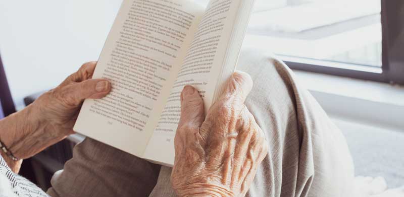 Die Hände einer alten Frau, die ein Buch hält und liest.
(c) Pixabay.com
