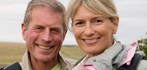 Silver Society – Menschen, die früher einmal «Senioren» hießen Eine ältere Frau und ein älterer Mann, die in die Kamera lächeln. (c) Protina Pharmazeutische GmbH/ Chris DeSilver