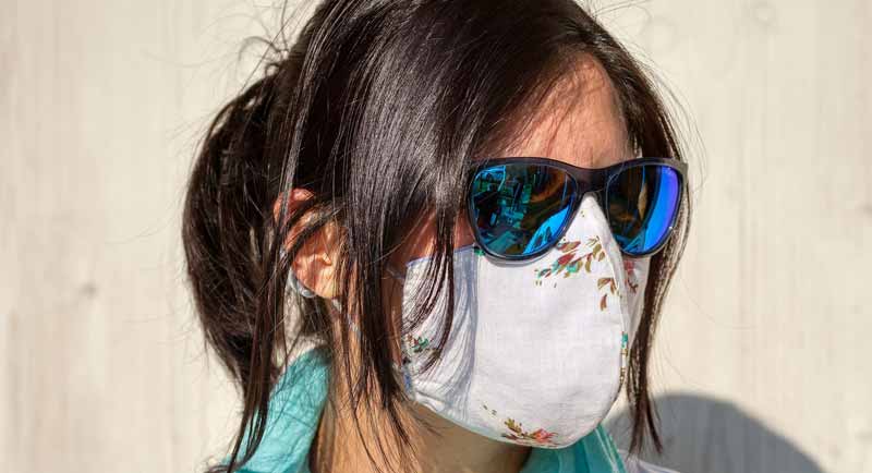 Der Kopf einer Frau mit Sonnenbrille und Mund-Nasen-Schutzmaske.
(c) Pixabay.com