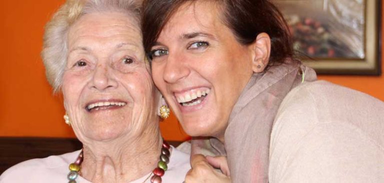 Eine alte und eine junge Frau, die ihre Köpfe zusammen haben und in die Kamera lachen. (c) Pixabay.com