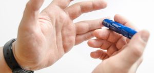 Diabetes positiv – gut leben mit Diabetes u. nicht ausbremsen lassen Die Hände eines Mannes mit einem Blutzuckermessgerät. (c) Pixabay.com