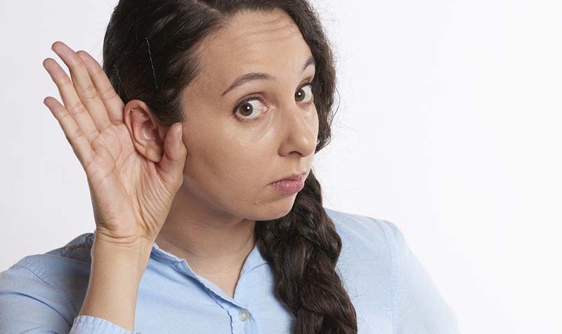 Eine Frau mit einer Hand an ihrem rechten Ohr, um besser zu hören, Stichwort beidseitiges Hören.
(c) Pixabay.com