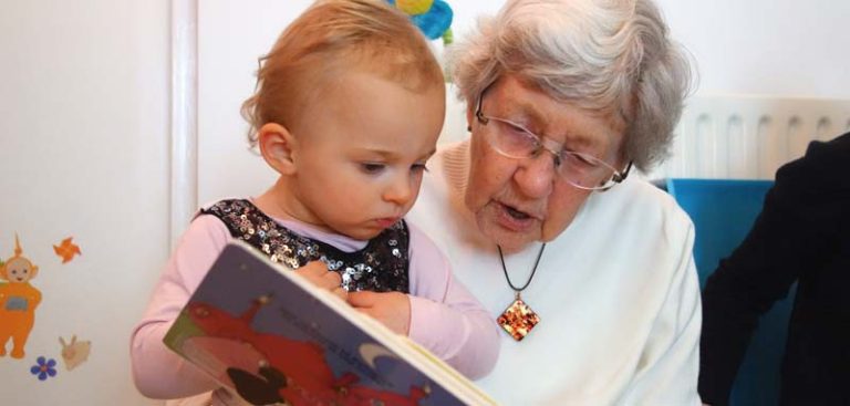 Eine Oma, die mit ihrem kleinen Enkelkind ein Bilderbuch anschaut. (c) Pixabay.com