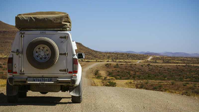 Ein Geländewagen auf einer langen Straße durch die Landschaft Namibias.
(c) Pixabay.com