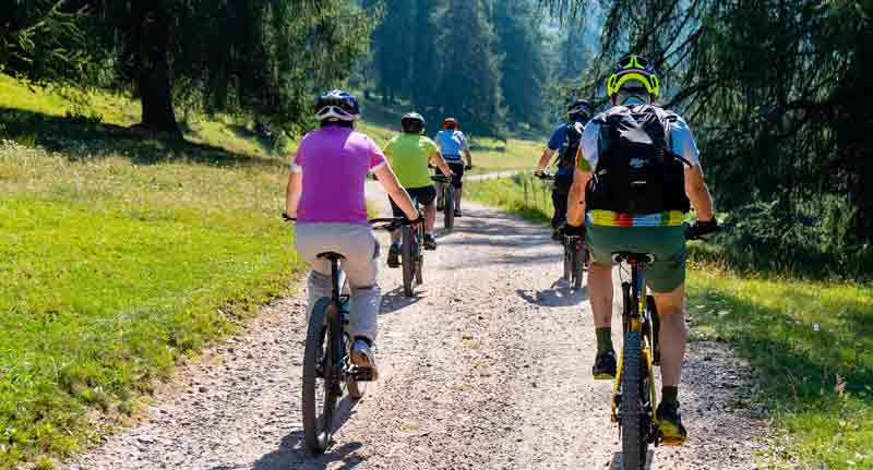 Eine Gruppe von Mountainbikern auf einem Schotterweg in den Alpen.
(c) Pixabay.com