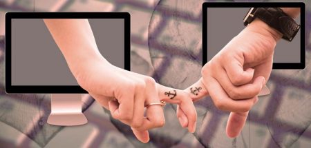 Illustration: zwei Hände, die aus einem Bildschirm ragen und sich mit den Zeigefingern gegenseitig halten. (c) Pixabay.com