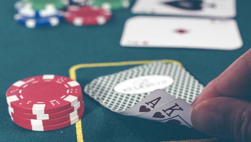 Ein Black Jack Spieler, der sich seine Karten anschaut, Stichwort Online Casino.
(c) Pixabay.com