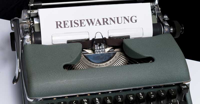 Eine alte Schreibmaschine mit dem Text "Reisewarnung", Stichwort darauf müssen ArbeitnehmerInnen beim Urlaub in Corona-Zeiten achten.
(c) Pixabay.com