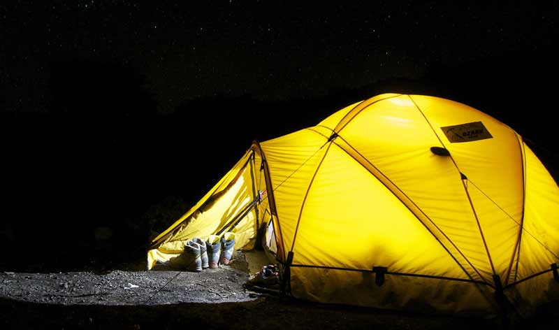 Ein beleuchtetes Zelt in der Nacht.
(c) Pixabay.com
