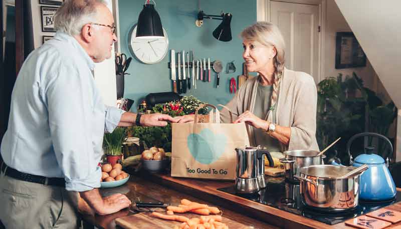 Keine Semmeln mehr im Müll – gegen Lebensmittelverschwendung 2 Ein älteres Ehepaar, dass in der Küche neugierig in ein Too Good To Go Sackerl schaut, Stichwort Lebensmittelverschwendung.
(c) Too Good To Go