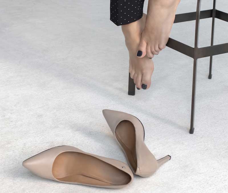 Die Füße einer auf einem Hocker sitzenden Frau, davor auf dem Boden liegend ihre Stöckelschuhe.
(c) Pixabay.com