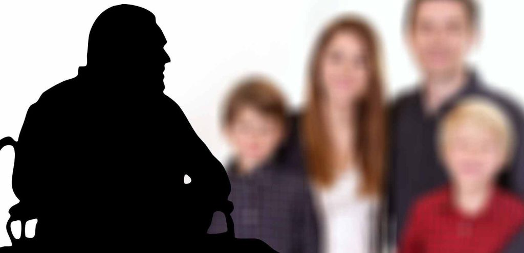 Silhouette eines Mannes in einem Rollstuhl, dahinter unscharf eine Familie mit zwei Kindern.
(c) Pixabay.com