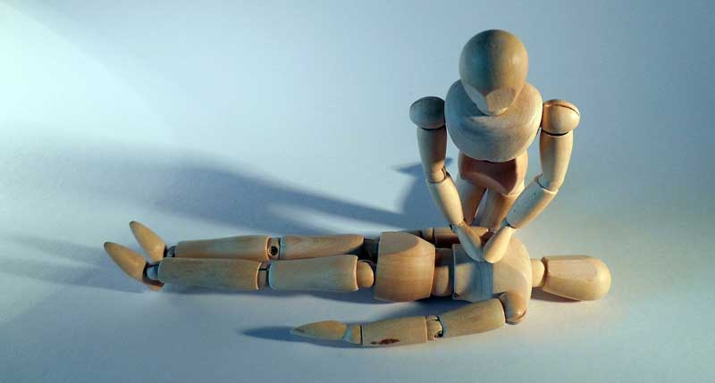 Zwei Holzfiguren, die eine Herzmassage darstellen, Stichwort Erste Hilfe.
(c) Pixabay.com