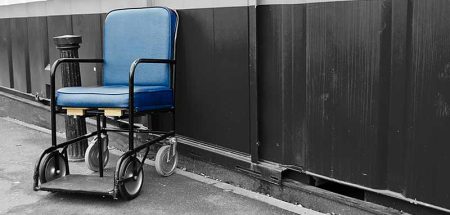 Ein leerer Rollstuhl an einer Wand auf einem leeren Gang. (c) Pixabay.com