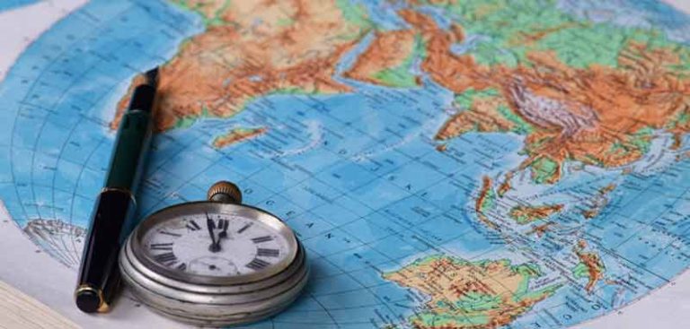 Eine Weltkarte, auf der eine Taschenuhr und ein Kugelschreiber liegen. (c) Pixabay.com