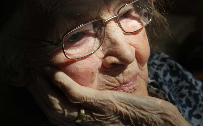 Das Gesicht einer traurig schauenden alten Frau, die ihren Kopf mit ihrer Hand stützt, Stichwort Dauerbelastung unserer Psyche seit Covid-19.
(c) Pixabay.com