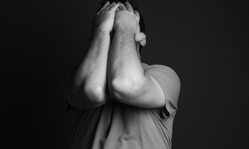 Ein Mann, der beide Arme vor seinem Kopf hält, Stichwort psychische Gesundheit.
(c) Pixabay.com