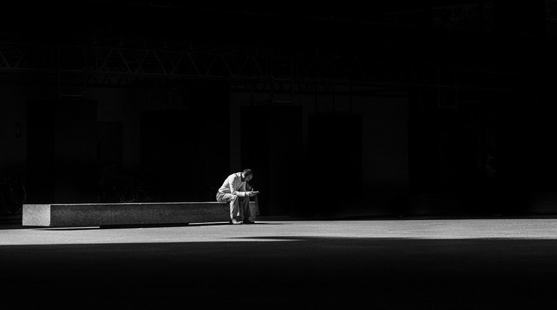 Ein Mann allein auf einer großen, langen Betonbank.
(c) Pixabay.com