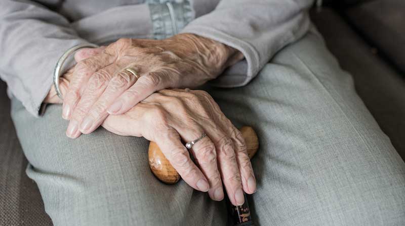 Pflege: würdige Lebens- nur mit motivierenden Arbeitsbedingungen 2 Die Hände einer alten Frau auf einem Gehstock.
(c) Pixabay.com