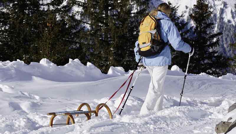 Covid-19: Was können wir für die kommende Wintersaison erwarten? 2 Eine Frau beim Wandern im Schnee mit einer Rodel, die sie hinter sich herzieht.
(c) Pixabay.com