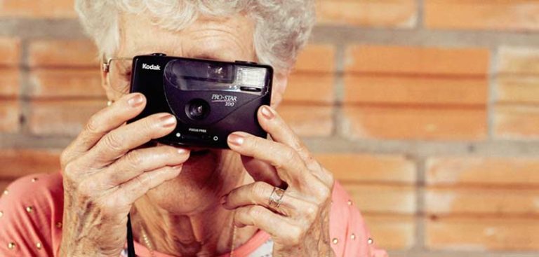 Der Kopf einer alten Frau, die durch eine Polaroid-Kamera schaut. (c) Pixabay.com