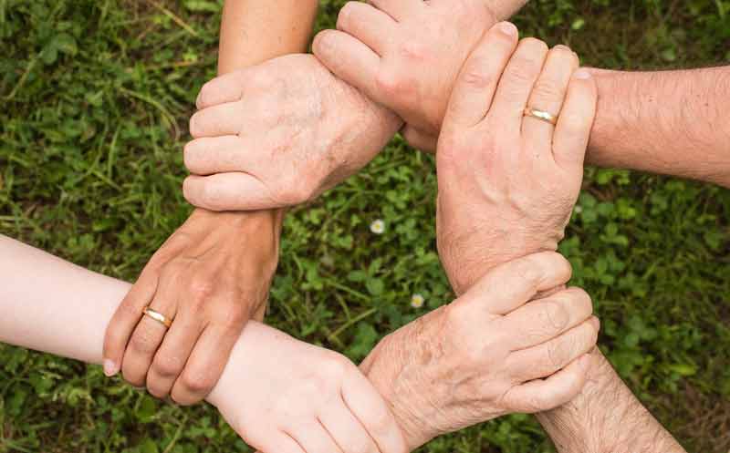 Gleiche medizinische Versorgung von Menschen mit Behinderungen 2 Die Hände von sechs Personen, die sich gegenseitig am Handgelenk haltend einen Kreis bilden.
(c) Pixabay.com