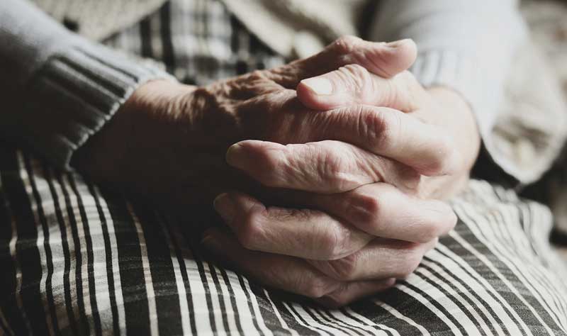 Die gefalteten Hände einer alten Frau auf ihrem Schoß, Stichwort Hautalterung.
(c) Pixabay.com