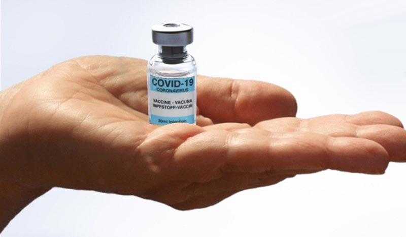 Eine Ampulle Covid-19 Impfstoff auf einer offenen Handfläche.
(c) Pixabay.com