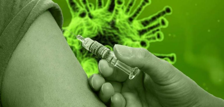 Eine Person, die eine Impfung in den Oberarm bekommt; im Hintergrund ein Corona-Virus. (c) Pixabay.com