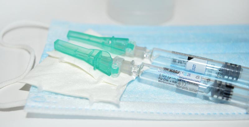 Zwei Injektionen mit Impfstoffen auf einer Mund-Nasen-Schutzmaske.
(c) Pixabay.com