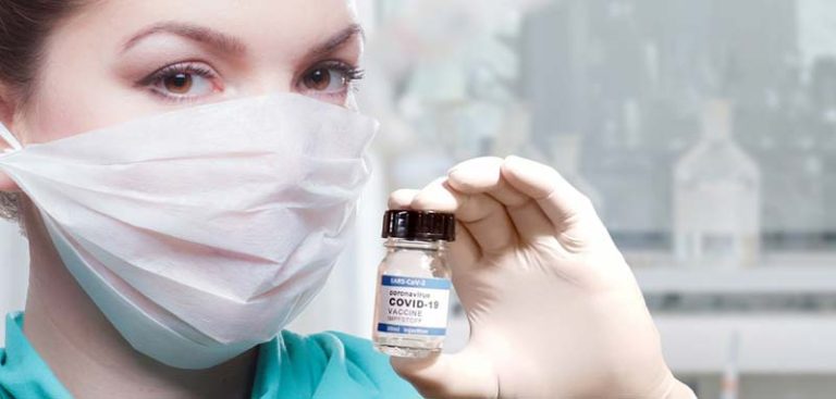 Eine Ärztin mit Mund-Nasen-Schutzmaske, die einen Covid-19-Impfstoff in der Hand hält. (c) Pixabay.com
