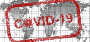 Das Gesundheits- und Sozialwesen im Spannungsfeld von Corona Eine Weltkarte, darüber ein "Covid-19-Stempel". (c) Pixabay.com