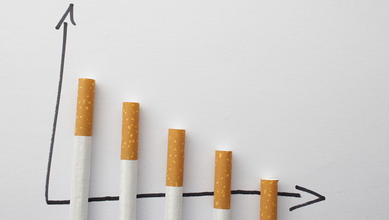 Von links nach rechts kleiner werdende Zigaretten, die auf einem Graphen liegen und das Krebsrisiko symbolisieren, das kleiner wird, je weniger man raucht.
(c) Pixabay.com