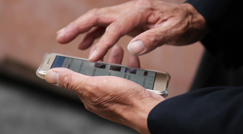 Die Hände eines alten Mannes, der ein Smartphone bedient.
(c) Pixabay.com