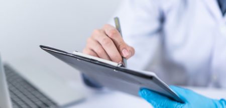 Die Hände eines Arztes, der eine Diagnose auf einen Patientenzettel schreibt. (c) Pixabay.com