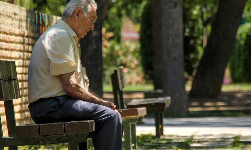 Ein alter Mann alleine auf einer Parkbank.
(c) Pixabay.com