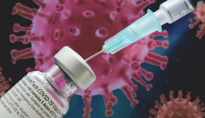 Eine Spritze in einer Corona-Impfstoff Ampulle, dahinter ein Corona-Virus.
(c) Pixabay.com