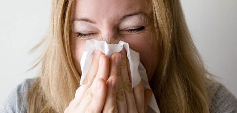 Nahaufnahme einer Frau, die sich die Nase putzt. (c) Pixabay.com
