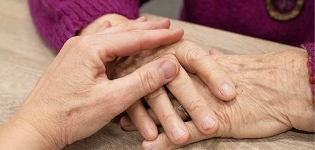 Die Hände einer älteren Frau auf einem Tisch, auf denen die von einer jüngeren liegt. (c) Pixabay.com