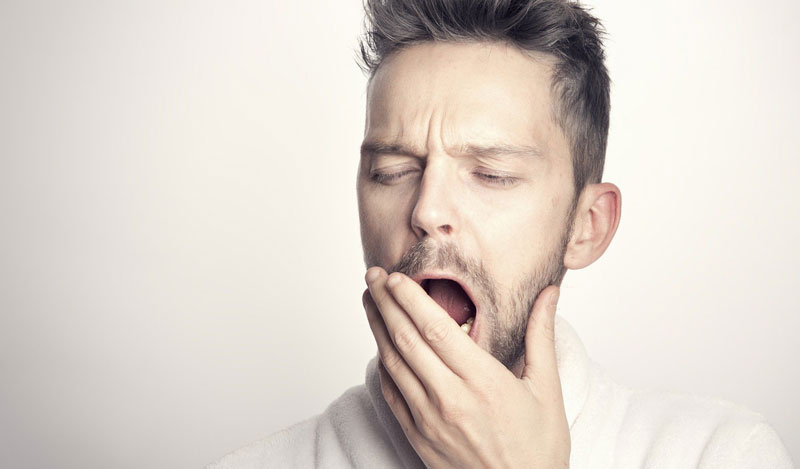 Ein gähnender Mann, der sich die Hand vor den Mund hält, Stichwort guter Schlaf.
(c) Pixabay.com